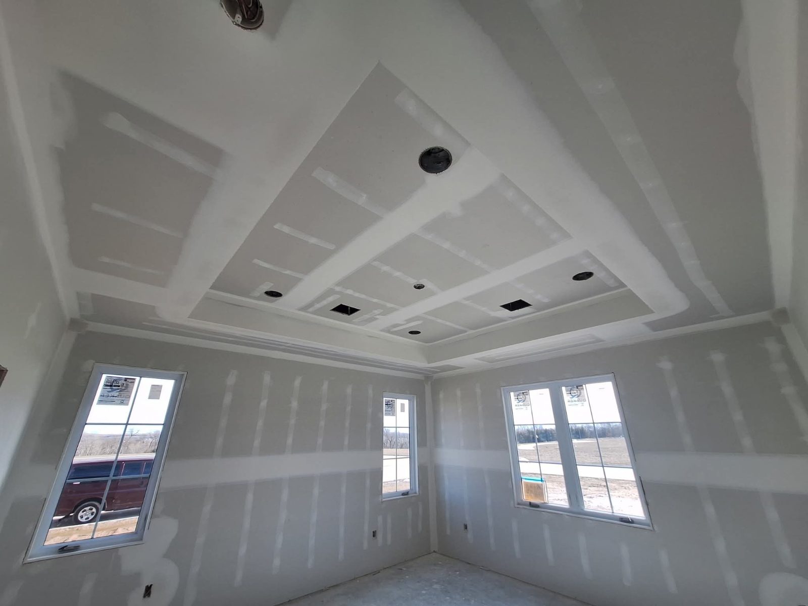 Finished drywall ceiling with tray details and recessed light openings