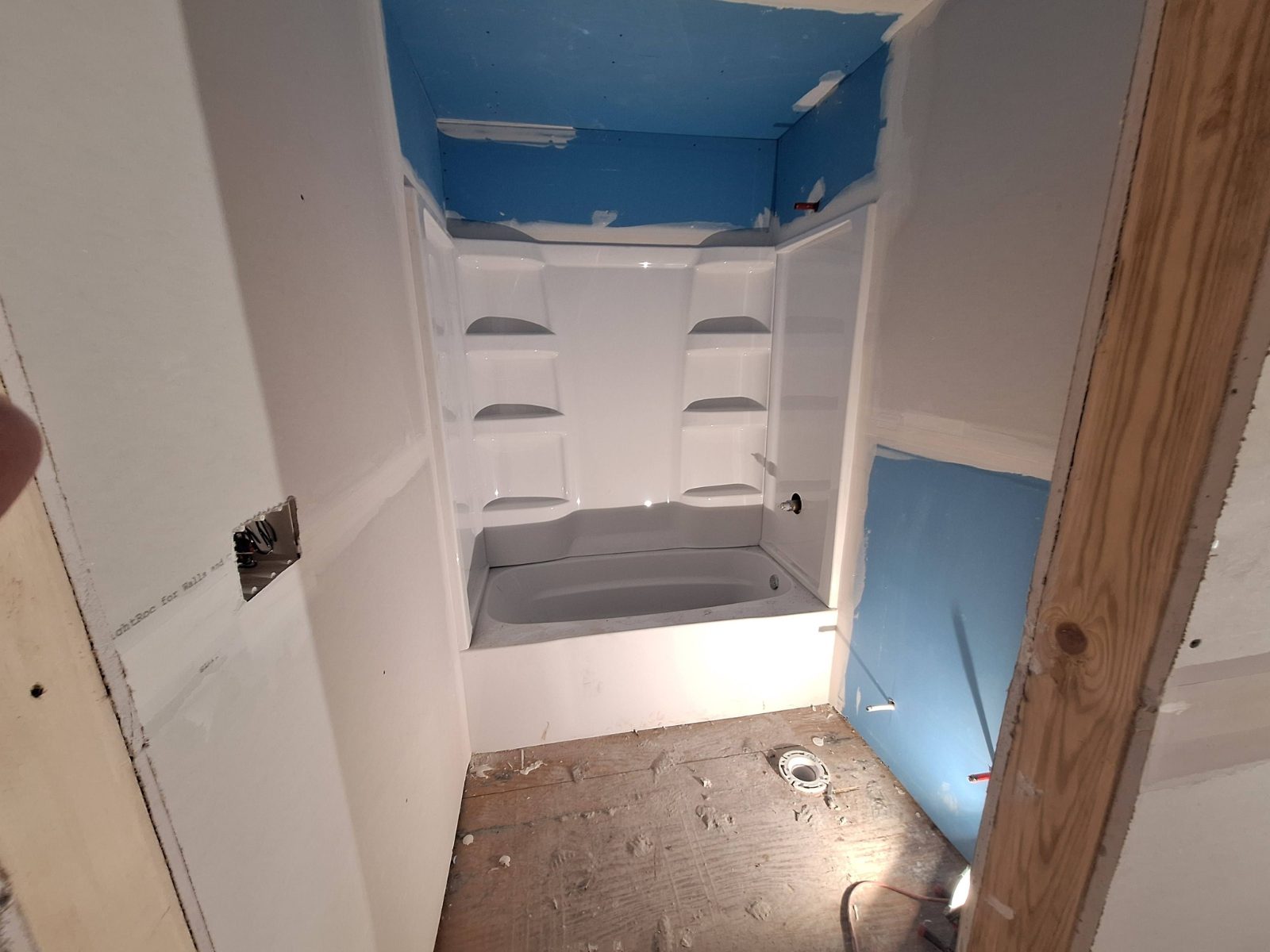 Bathroom tub surround with moisture-resistant board and drywall finishing