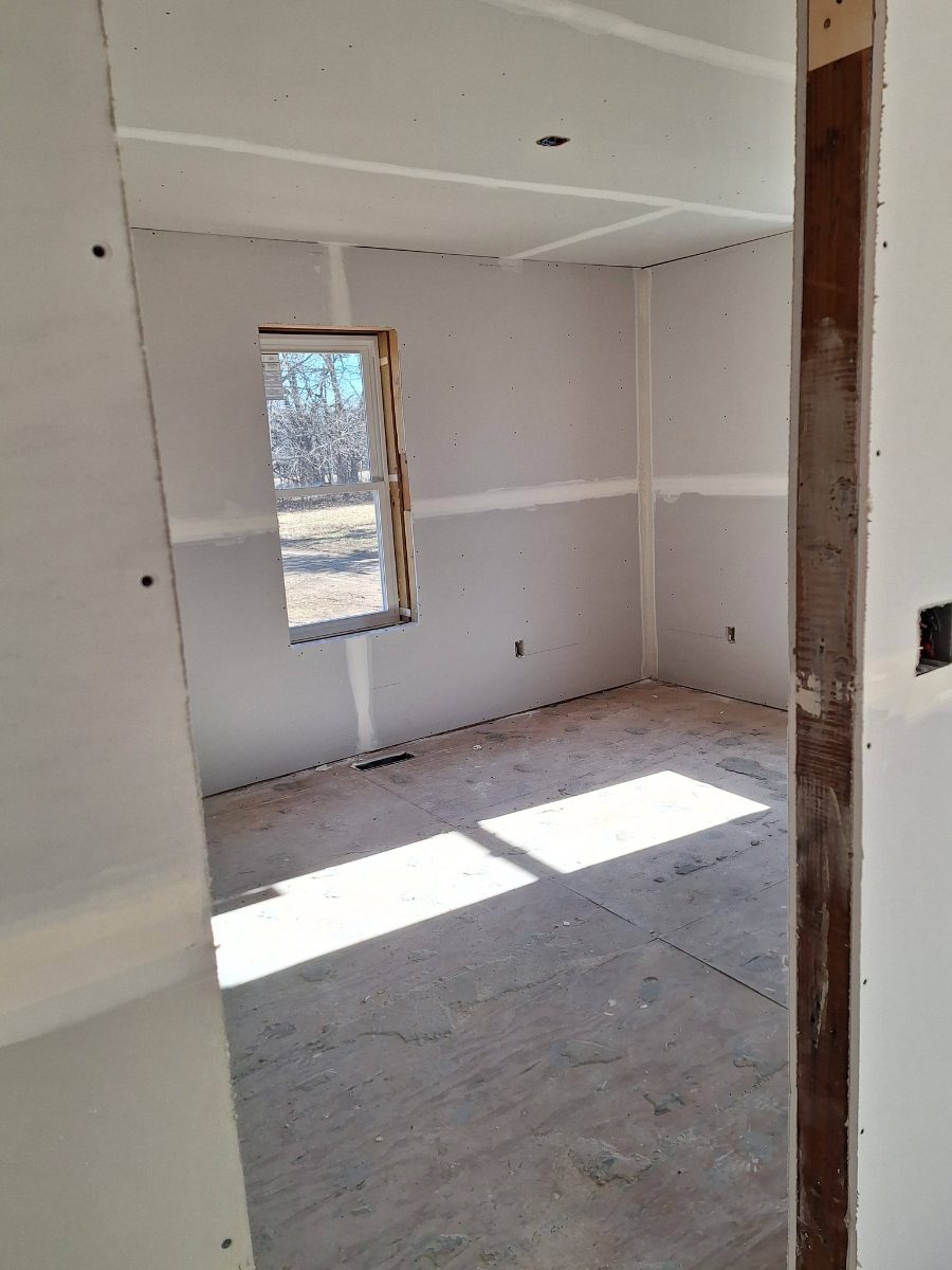 Drywall installed around windows and walls in a residential space
